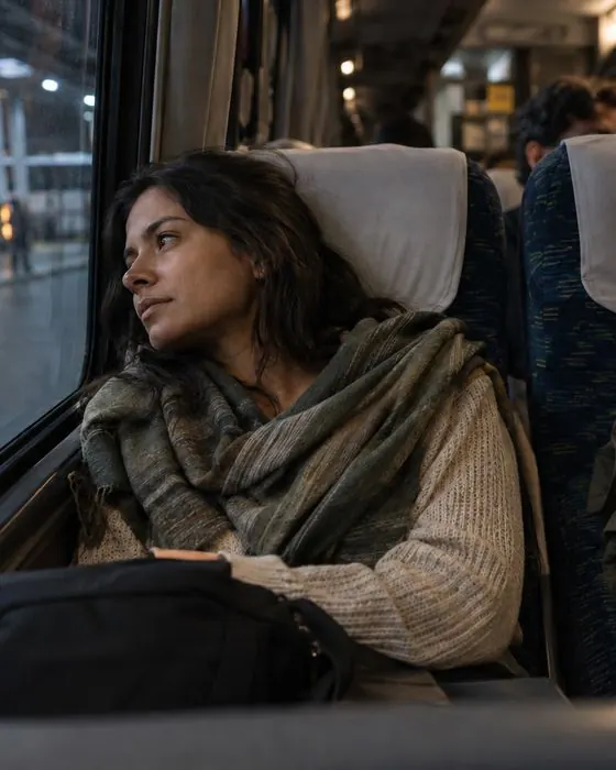 Júlia volta para casa de ônibus, olhando pela janela.